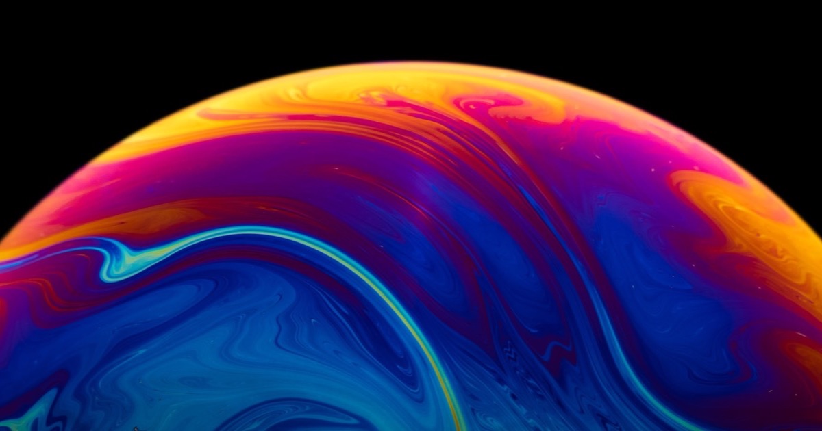 An iridescent soap bubble against a black background